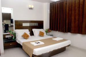 1 dormitorio con 1 cama con 2 toallas en Hotel Happiness en Surat