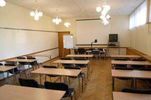 een klaslokaal met tafels en stoelen en een whiteboard bij Park Hotel Kekava in Ķekava