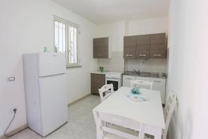 a kitchen with a white table and a white refrigerator at Camping Lido di Salerno in Pontecagnano