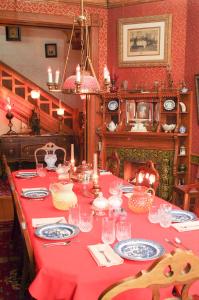 uma mesa longa com uma toalha de mesa vermelha em The Richards House em Dubuque