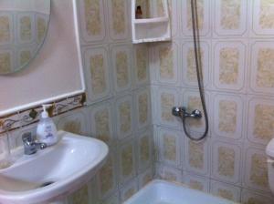 y baño con ducha, lavabo y espejo. en Hostal Patrimonial Angelmó, en Puerto Montt