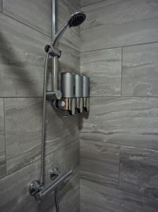 a shower with a shower head in a bathroom at Citi North in Belfast