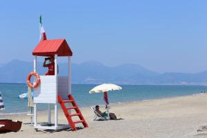 a lifeguard tower on a beach with two people at Camping Lido di Salerno in Pontecagnano