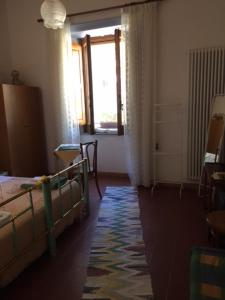Schlafzimmer mit einem Bett, einem Fenster und einem Teppich in der Unterkunft Casa Ferrari in Gerace