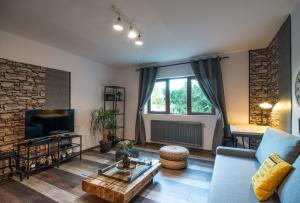 a living room with a blue couch and a tv at Rent in Cluj Apartments in Cluj-Napoca