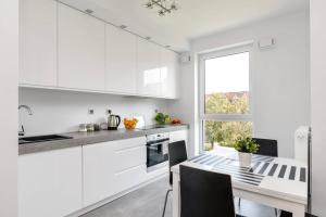 a white kitchen with a table and a window at Good Time Apartments Kościelna 17 19 in Poznań