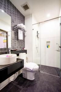 a bathroom with a sink and a toilet and a shower at Tara Place Hotel Bangkok in Bangkok