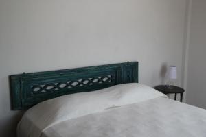 1 cama con cabecero verde en un dormitorio en Casa Verde Albarrada en Mompox