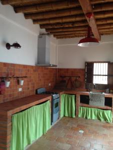 una cocina con cortinas verdes en los mostradores en Casa Verde Albarrada en Mompox
