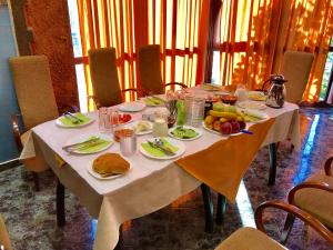 una mesa con platos de comida y fruta. en RAMIS Hotel & Outdoor Sports Center, en Përmet