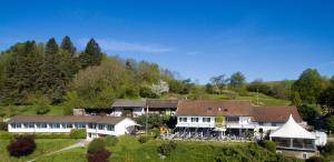 a large white house in the middle of a hill at Le Mont-Vully - Hôtel Restaurant in Haut-Vully