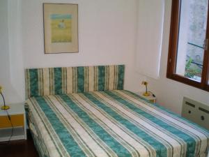 ラパッロにあるRapallo Apartmentのベッドルーム1室(ストライプ掛け布団付きのベッド1台付)