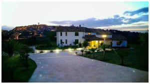 duży biały dom z oświetleniem na podjeździe w obiekcie Villaggio Cristina w mieście Monteodorisio