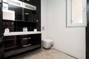 a bathroom with a sink and a toilet and a mirror at Teo Apartment in Pula +27 photos