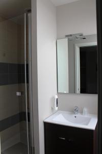 a bathroom with a sink and a mirror at Aux Chambres du Mont in Huisnes-sur-Mer