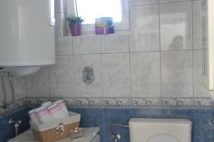 a bathroom with a toilet and a sink and a window at Holiday Home Zdenka in Rogoznica