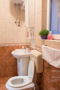 a bathroom with a toilet and a sink at Holiday Home Zdenka in Rogoznica