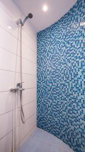 a bathroom with a shower with a blue tiled wall at Petaluda House 1 in Athens