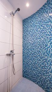 ein Bad mit einer Dusche und einer blau gefliesten Wand in der Unterkunft Petaluda House 1 in Athen