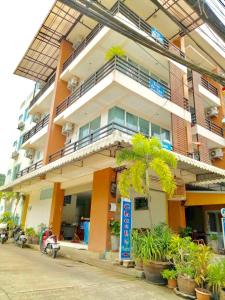 un bâtiment avec un palmier en face dans l'établissement J Apartment, à Ao Nang Beach