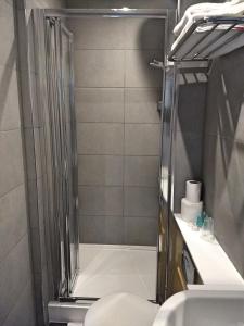 a bathroom with a shower with a toilet and a sink at Garden Court Hotel in London