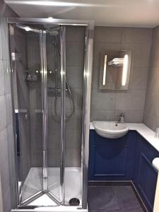 a bathroom with a shower and a sink at Garden Court Hotel in London