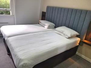 ロンドンにあるガーデン コート ホテルのベッド(白いシーツ、枕付)