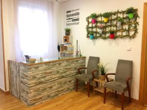 a bar in a room with two chairs and a counter at Alojamiento Jaén in Madrid