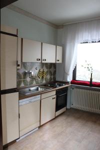 a kitchen with white cabinets and a sink and a window at Ferienwohnung Wölfel in Schwarzenbach an der Saale