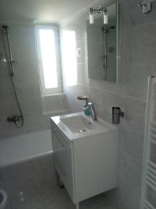 a white bathroom with a sink and a shower at Apartment Elena in Piraeus