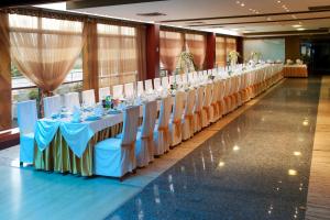 a row of tables and chairs in a banquet hall at Hotel Aros in Tychy