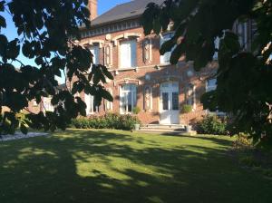 a large brick building with a lawn in front of it at L'hostellerie du chateau in Mesnil-Saint-Nicaise