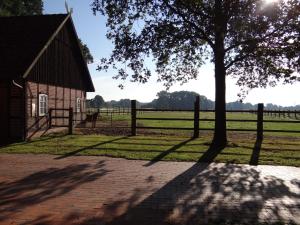 a barn with a tree and a fence at Ferienhaus Poppe in Löningen