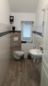 a bathroom with a toilet and a sink at Ferienhaus Poppe in Löningen +6 photos