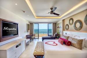 a living room with a large bed and a tv at Hideaway at Royalton Riviera Cancun, An Autograph Collection All- Inclusive Resort - Adults Only in Puerto Morelos