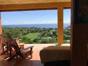 1 dormitorio con vistas al océano desde una ventana en Welcoming vibes, en Treasure Beach