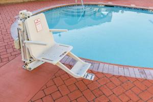 a lounge chair sitting next to a swimming pool at Kings Inn Anaheim at The Park & Convention Center in Anaheim