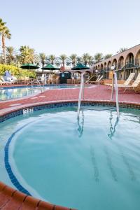 a large pool of water with tables and umbrellas at Kings Inn Anaheim at The Park & Convention Center in Anaheim