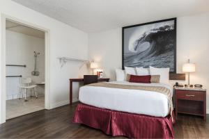 a hotel room with a large bed and a bathroom at Kings Inn Anaheim at The Park & Convention Center in Anaheim
