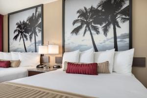 a hotel room with two beds with palm trees at Kings Inn Anaheim at The Park & Convention Center in Anaheim