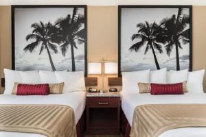 two beds in a hotel room with palm trees at Kings Inn Anaheim at The Park & Convention Center in Anaheim