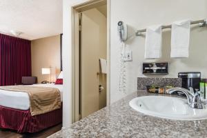 a bathroom with a sink in a hotel room at Kings Inn Anaheim at The Park & Convention Center in Anaheim