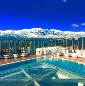 un hotel con piscina con montagne sullo sfondo di Icon Hotel a Santiago