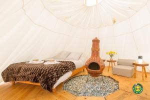 - une chambre avec un lit dans une tente dans l'établissement Le Moulin Aux Moines, à Croissy-sur-Celle