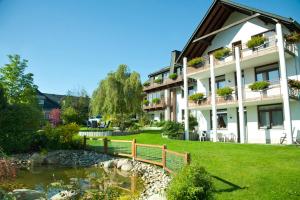 ein Gebäude mit einer Bank vor einem Teich in der Unterkunft Haus Alexandra inkl MeineCard Plus in Willingen