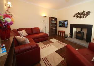 a living room with a couch and a fireplace at Ivybank Cottage in Lochgoilhead