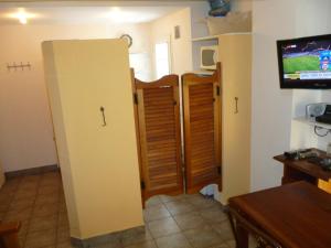 een kamer met drie deuren en een tv aan een muur bij Perla Italiano in Buenos Aires