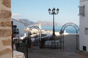 un patio con mesas, luz de la calle y el océano en Casa con encanto en Altea, en Altea