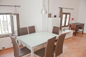 Un comedor con una mesa y sillas blancas. en Casa con encanto en Altea, en Altea