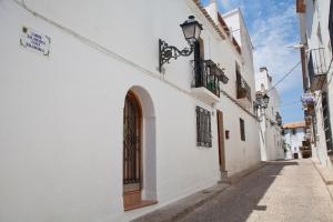 un callejón con edificios blancos y un semáforo en Casa con encanto en Altea, en Altea